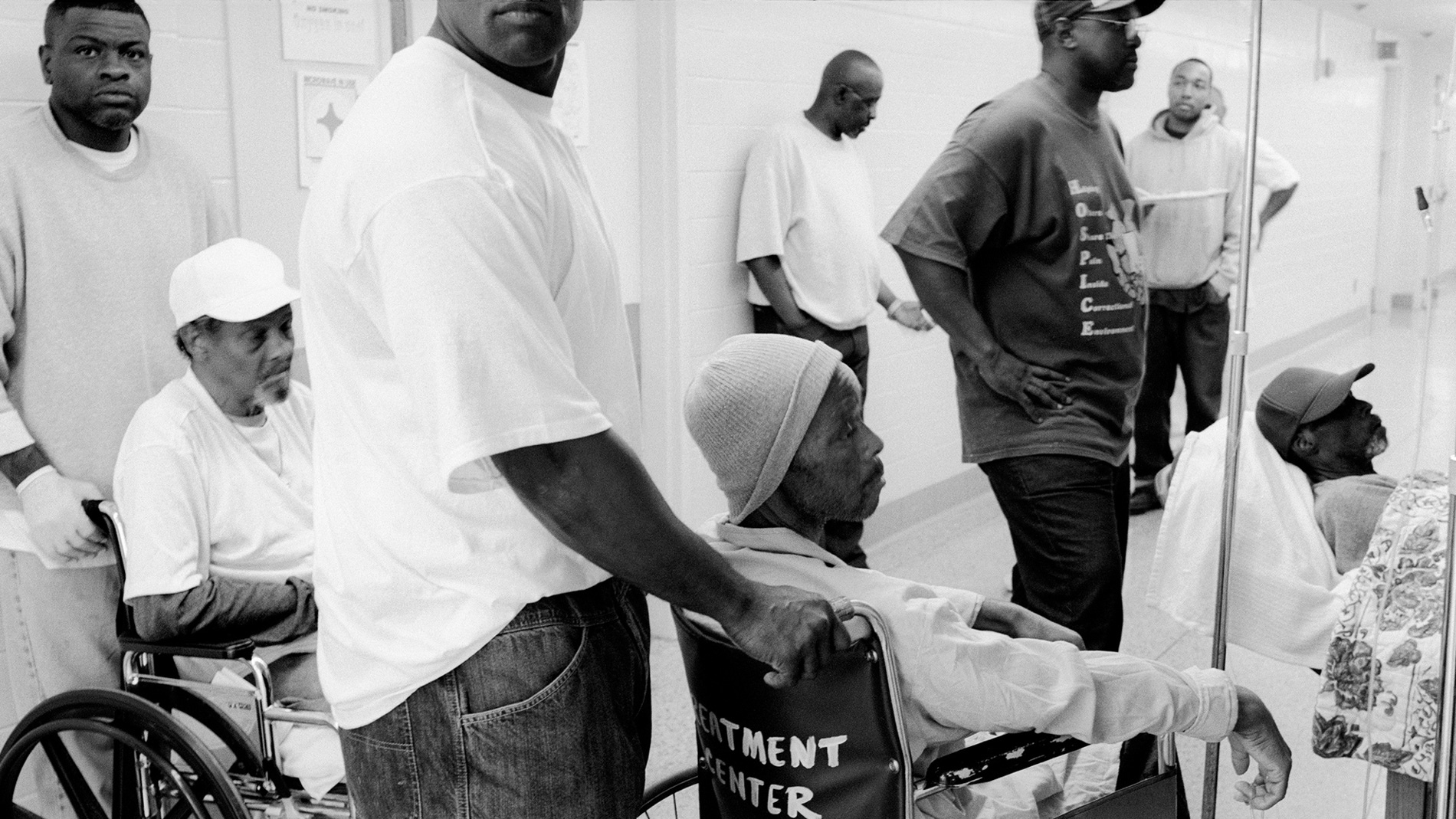 Men push men in wheelchairs