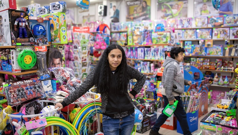 A young woman surrounded by brightly colored toys