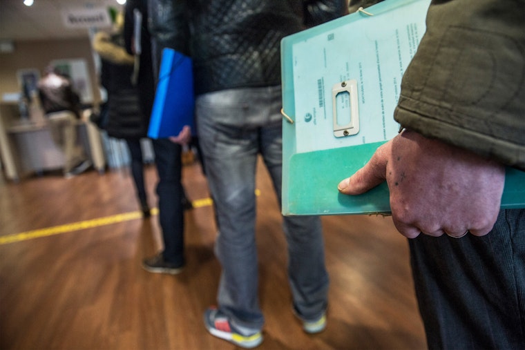 People standing in line holding documents