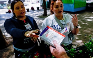 A volunteer hands out naloxone.