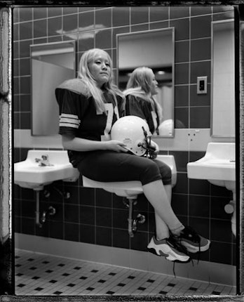 A woman sitting on a sink