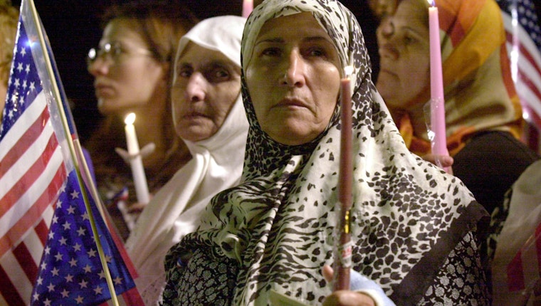 A group of people holding candles and American Flags