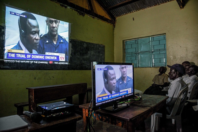 People watch a broadcast of the International Criminal Court trial of Dominic Ongwen for war
crimes in Lukodi, Uganda on December 6, 2016. Photo credit: © Isaac Kassamani/AFP/Getty People watch the broadcast of a trial.
