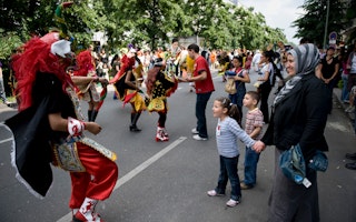 Families interacting with carnival performers