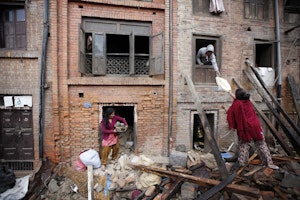 Women retrieve belongings from rubble