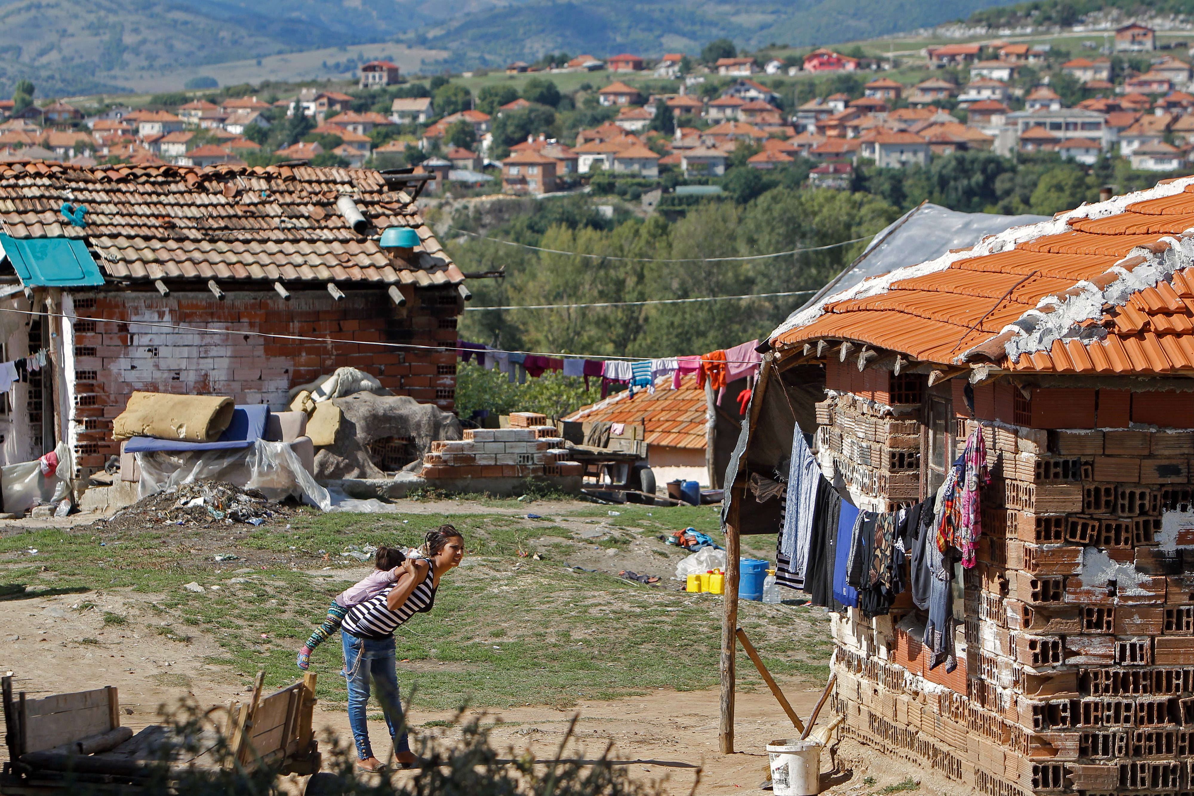 A woman with a child outside a home