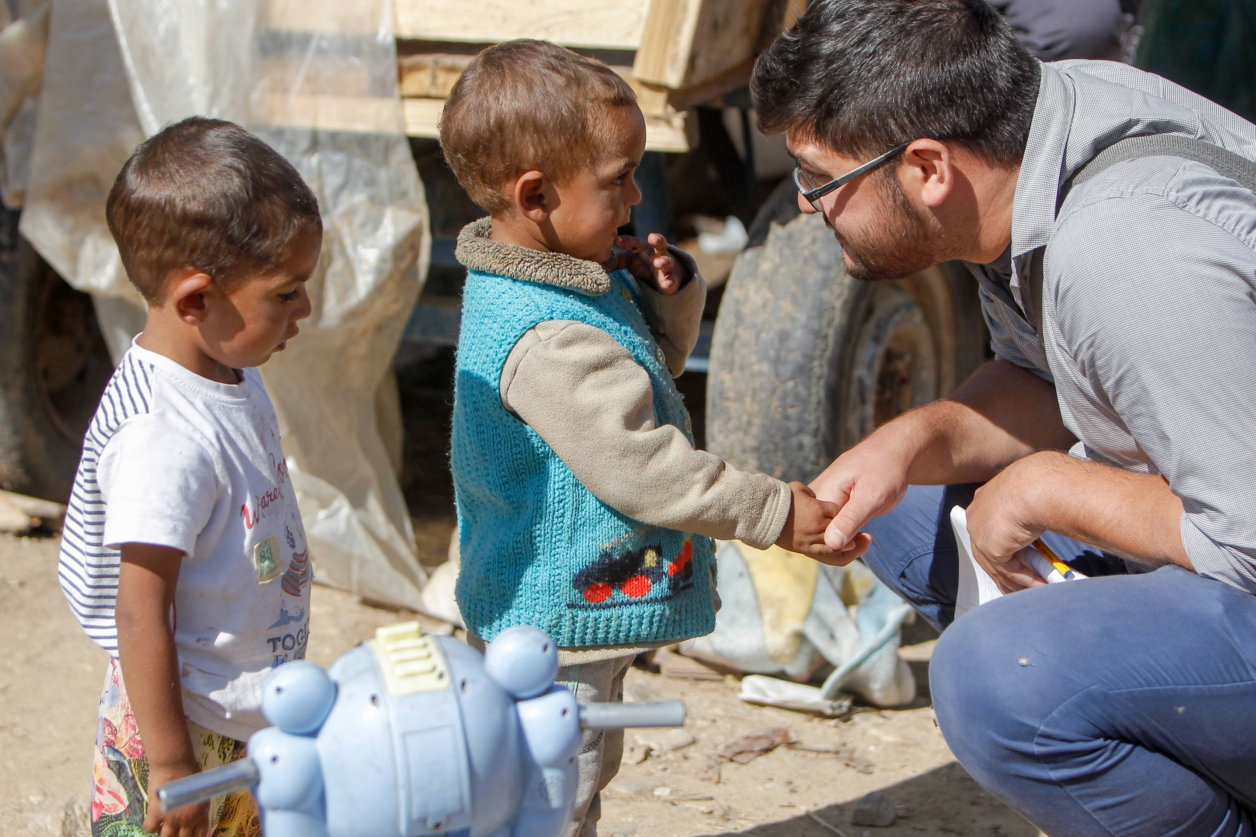 A man speaking to two children