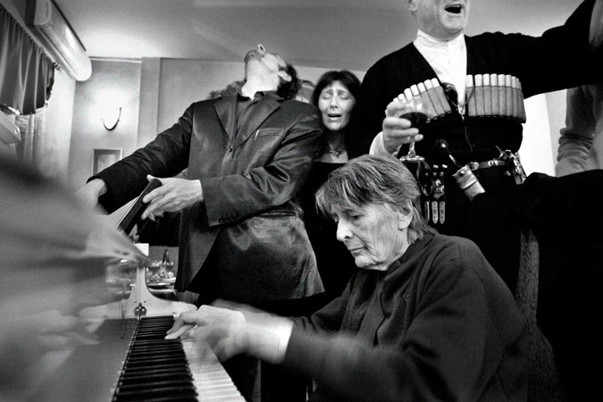 People gather around piano