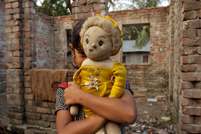 Young girl holding doll.