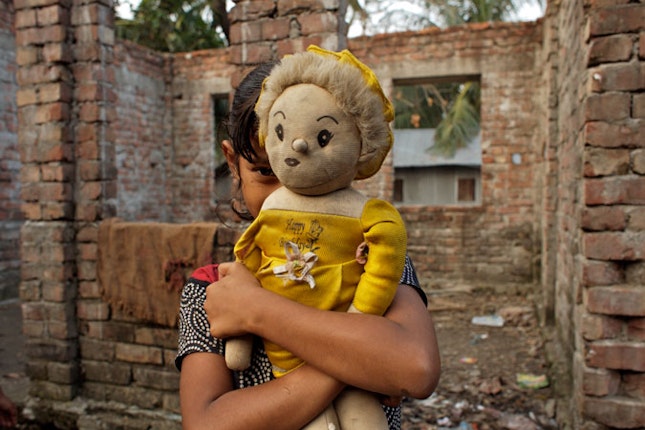 Young girl holding doll.