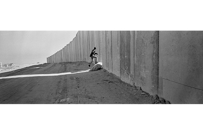 Man running through break in wall.