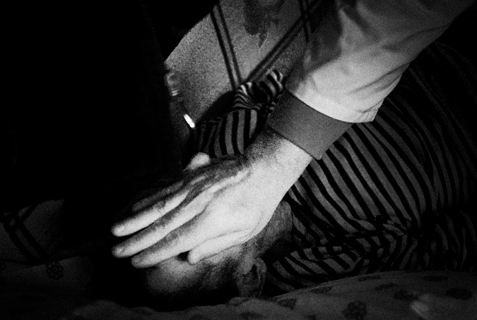 Doctor's hand covering dead man's face