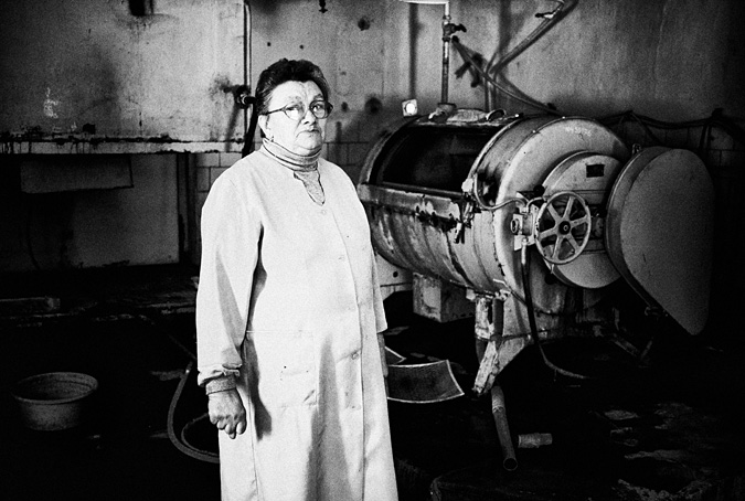 Woman standing in front of industrial laundry machine