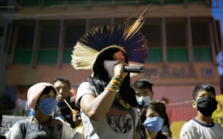 Climate activists take part in an international climate demonstration in front of the Brazilian Institute for Environment and Renewable Natural Resources in Sao Paulo, Brazil, on September 25, 2020. Photo credit:  © Andre Lucas/dpa/Getty A climate activist holds a microphone among a crowd