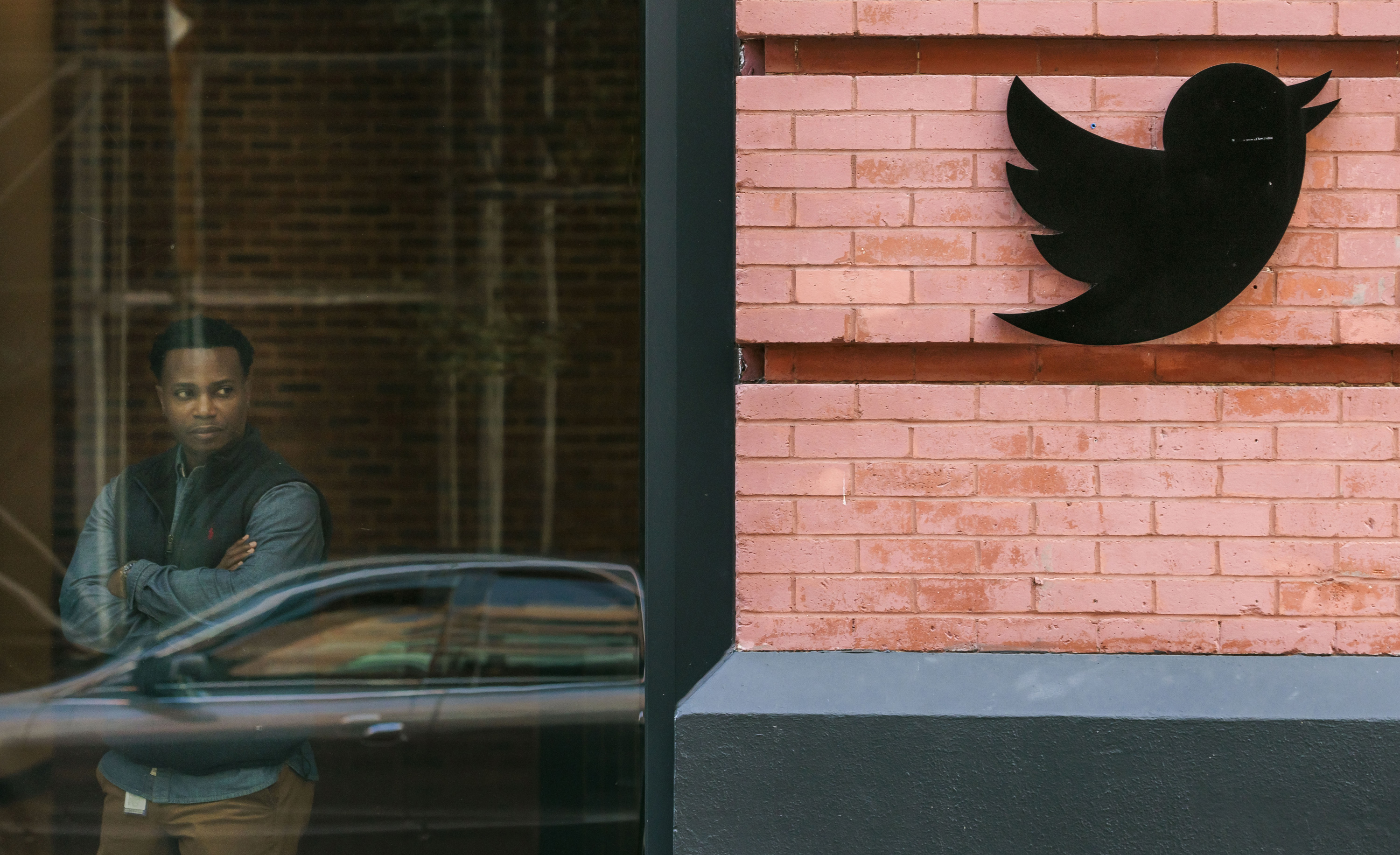 An employee looks out the window of the Twitter offices