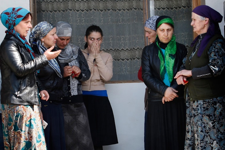 A group of women standing outside a home