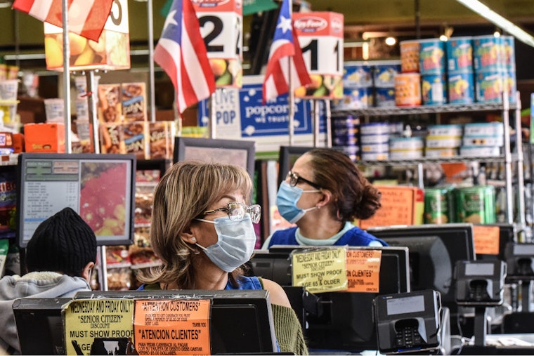 Two women at the registers in a grocery store