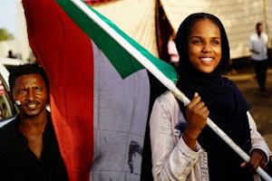 A protester holds a Sudanese national flag during a demonstration in front of the defense ministry compound in Khartoum, Sudan, May 2, 2019. Photo credit: © Umit Bektas/Reuters/Newscom A woman holding a flag