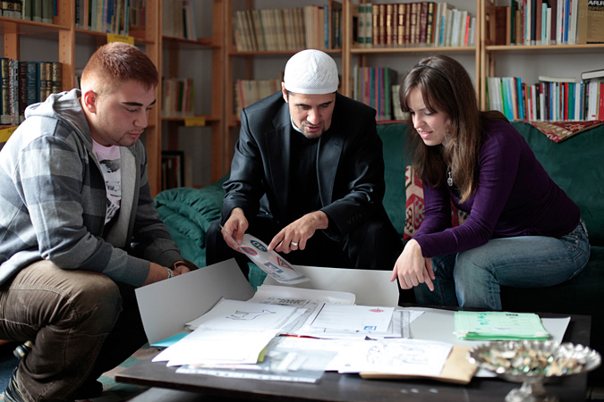 Students sitting around table looking at drawings