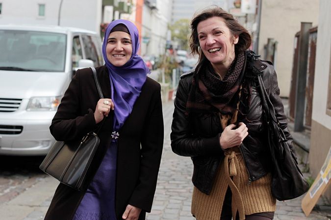Two women walking down sidewalk