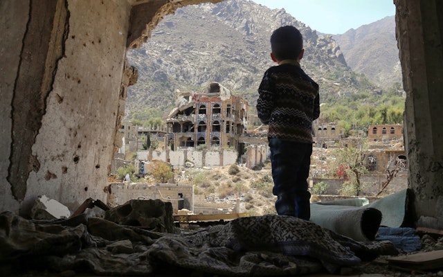 A child looks out at buildings.