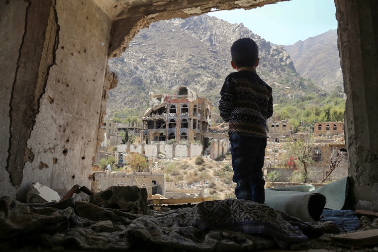 A child looks out at buildings.