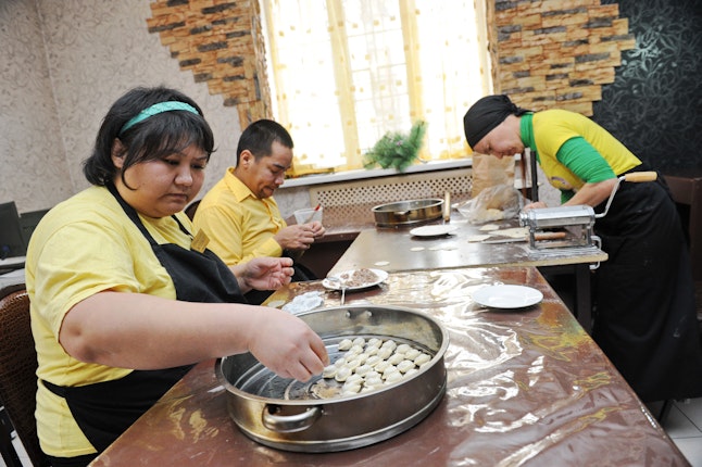 People making dumplings at a large table