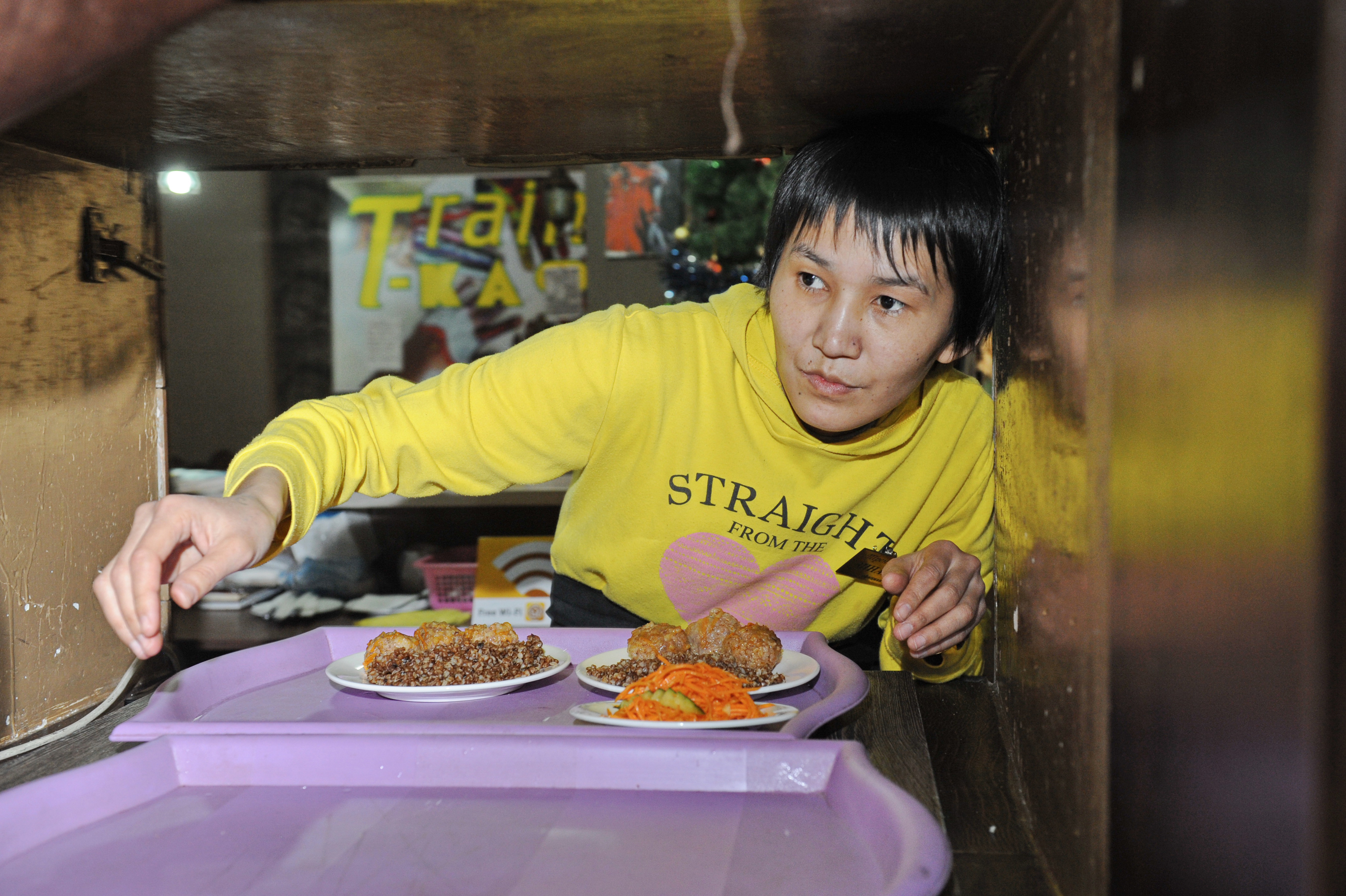 A women passes a tray of food through a window