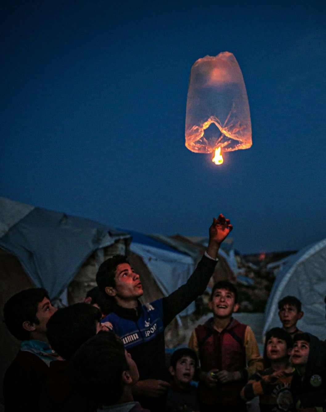Children lighting a floating lamp