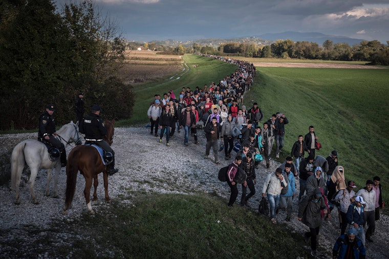 Line of refugees walking on a road